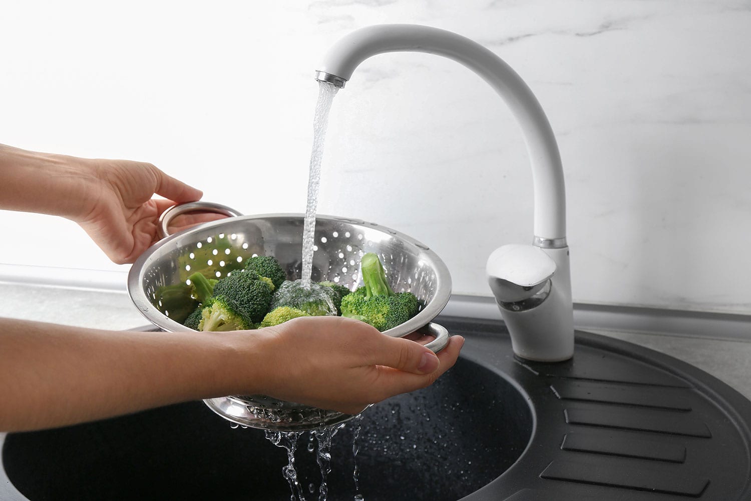 washing broccoli in the sink